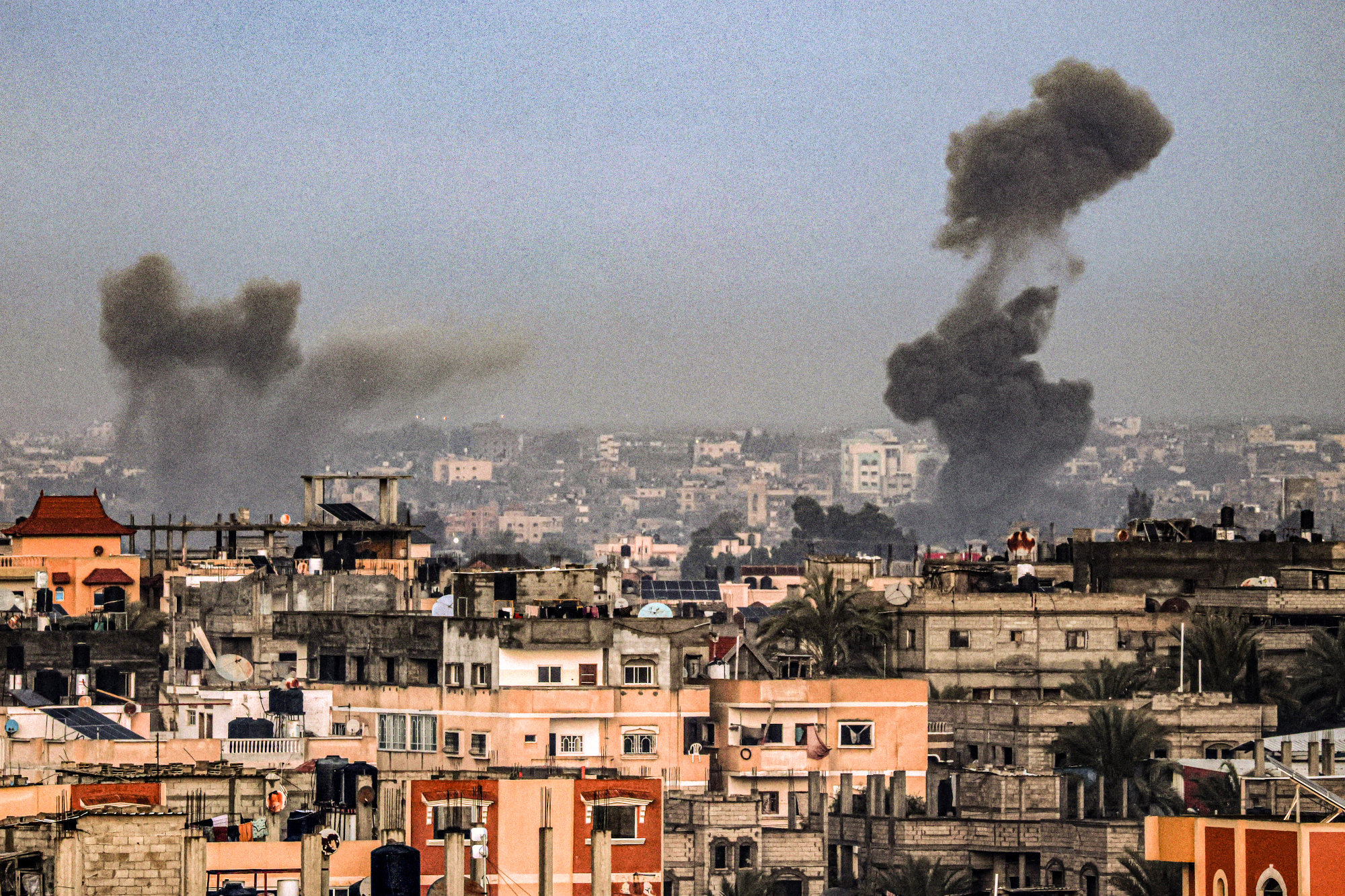 A picture taken from Rafah in the southern Gaza Strip shows smoke rising over buildings in Khan Yunis during Israeli bombardment on 2 February 2024, as fighting continues between Israel and the Palestinian Hamas group. (Picture: SAID KHATIB / AFP)