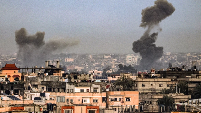 A picture taken from Rafah in the southern Gaza Strip shows smoke rising over buildings in Khan Yunis during Israeli bombardment on 2 February 2024, as fighting continues between Israel and the Palestinian Hamas group. (Picture: SAID KHATIB / AFP)