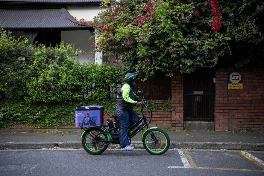 Pitcher arrives at her delivery destination in leafy Newlands, not far from the Claremont hub where she bases herself waiting for orders. Riders prefer to accept deliveries that aren’t too far and will often not choose delivery requests from dangerous areas. Picture: David Harrison/@GroundUp News Pitcher arrives at her delivery destination in leafy Newlands, not far from the Claremont hub where she bases herself waiting for orders. Riders prefer to accept deliveries that aren’t too far and will often not choose delivery requests from dangerous areas. Picture: David Harrison/@GroundUp News