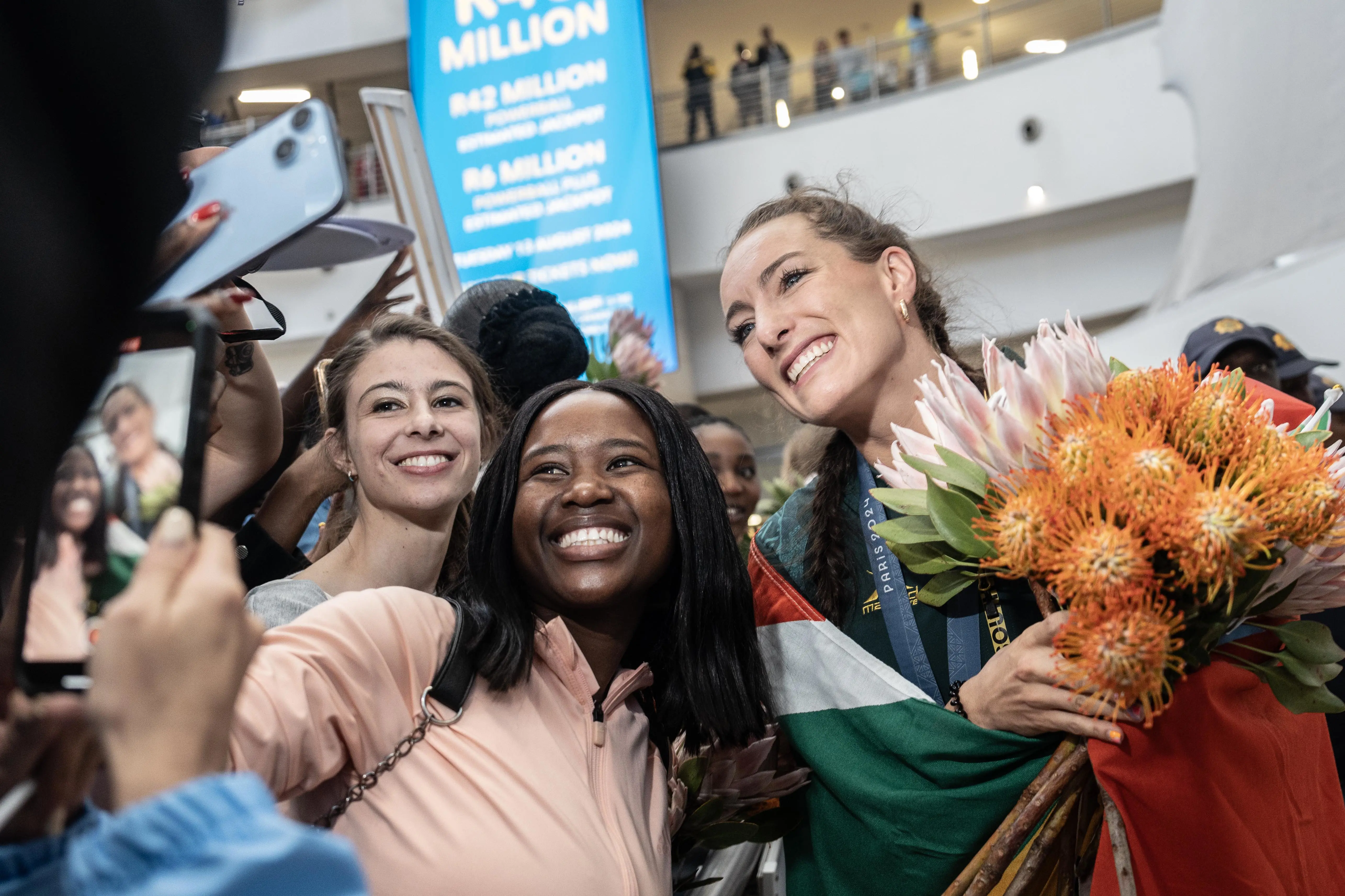 Gold Olympic medallist Tatjana Smith is handed bouquets of flowers as she arrives at at OR Tambo International Airport Photo: Jacques Nelles/Eyewitness News Gold Olympic medallist Tatjana Smith is handed bouquets of flowers as she arrives at at OR Tambo International Airport Photo: Jacques Nelles/Eyewitness News
