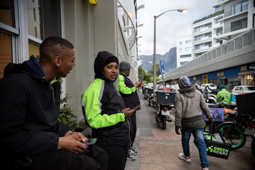 Waiting for orders to come through on the Uber Eats App, Pitcher and her colleague Kyle Abels sit outside Cavendish Square on a Saturday afternoon. Picture: David Harrison/@GroundUp News Waiting for orders to come through on the Uber Eats App, Pitcher and her colleague Kyle Abels sit outside Cavendish Square on a Saturday afternoon. Picture: David Harrison/@GroundUp News