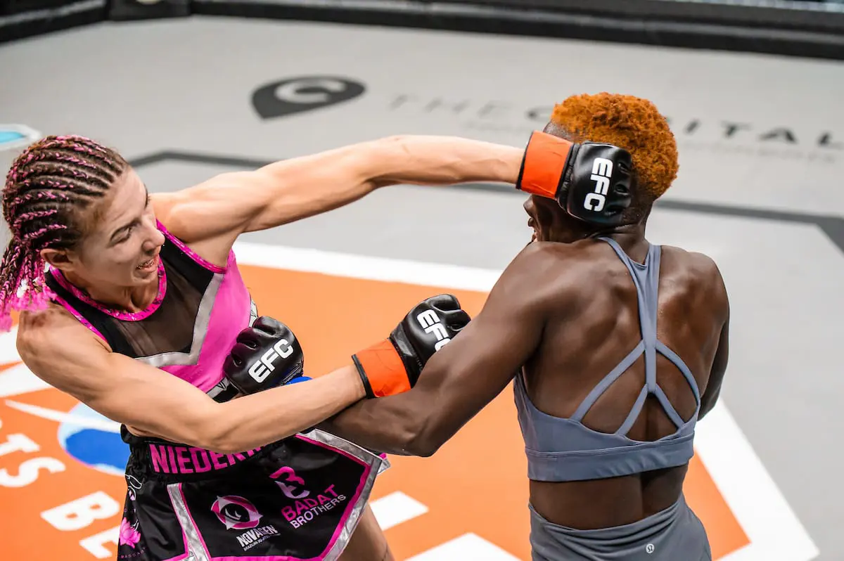 Professional female MMA fighter Ceileigh “Smiley Savage” Niedermayr (wearing pink) in a match against Uganda’s Rebecca “Warrior” Amongi. Picture: EFCWorldWide/Supplied. Professional female MMA fighter Ceileigh “Smiley Savage” Niedermayr (wearing pink) in a match against Uganda’s Rebecca “Warrior” Amongi. Picture: EFCWorldWide/Supplied.