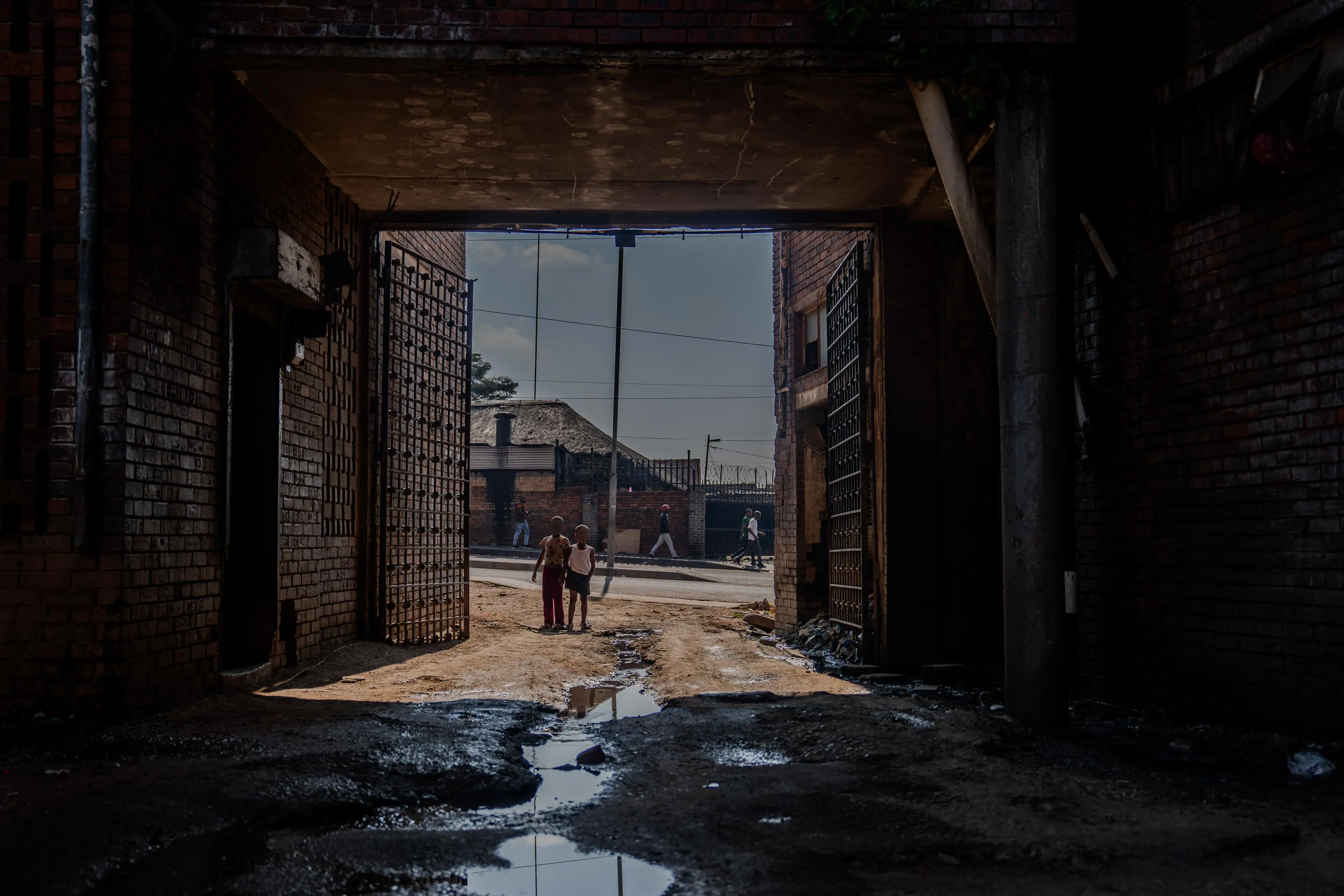 The constant flow of sewage at the hostel entrance not only stains the pavement but also reflects a deeper neglect. Photo: Sphamandla Dlamini/EWN The constant flow of sewage at the hostel entrance not only stains the pavement but also reflects a deeper neglect. Photo: Sphamandla Dlamini/EWN