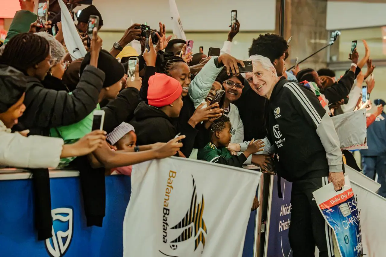 Bafana Bafana coach Hugo Broos with supporters at OR Tambo International Airport following the team's arrival in South Africa from the FIFA World Cup. Picture: Sphamandla Dlamini/EWN