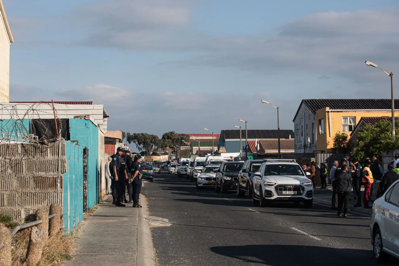 Residents looked on as Western Cape Premier Alan Winde and law enforcement teams conducted a safety walk from the Mitchells Plain Police Station to Beacon Valley on 13 October 2025. Picture: Kayleen Morgan/EWN Residents looked on as Western Cape Premier Alan Winde and law enforcement teams conducted a safety walk from the Mitchells Plain Police Station to Beacon Valley on 13 October 2025. Picture: Kayleen Morgan/EWN