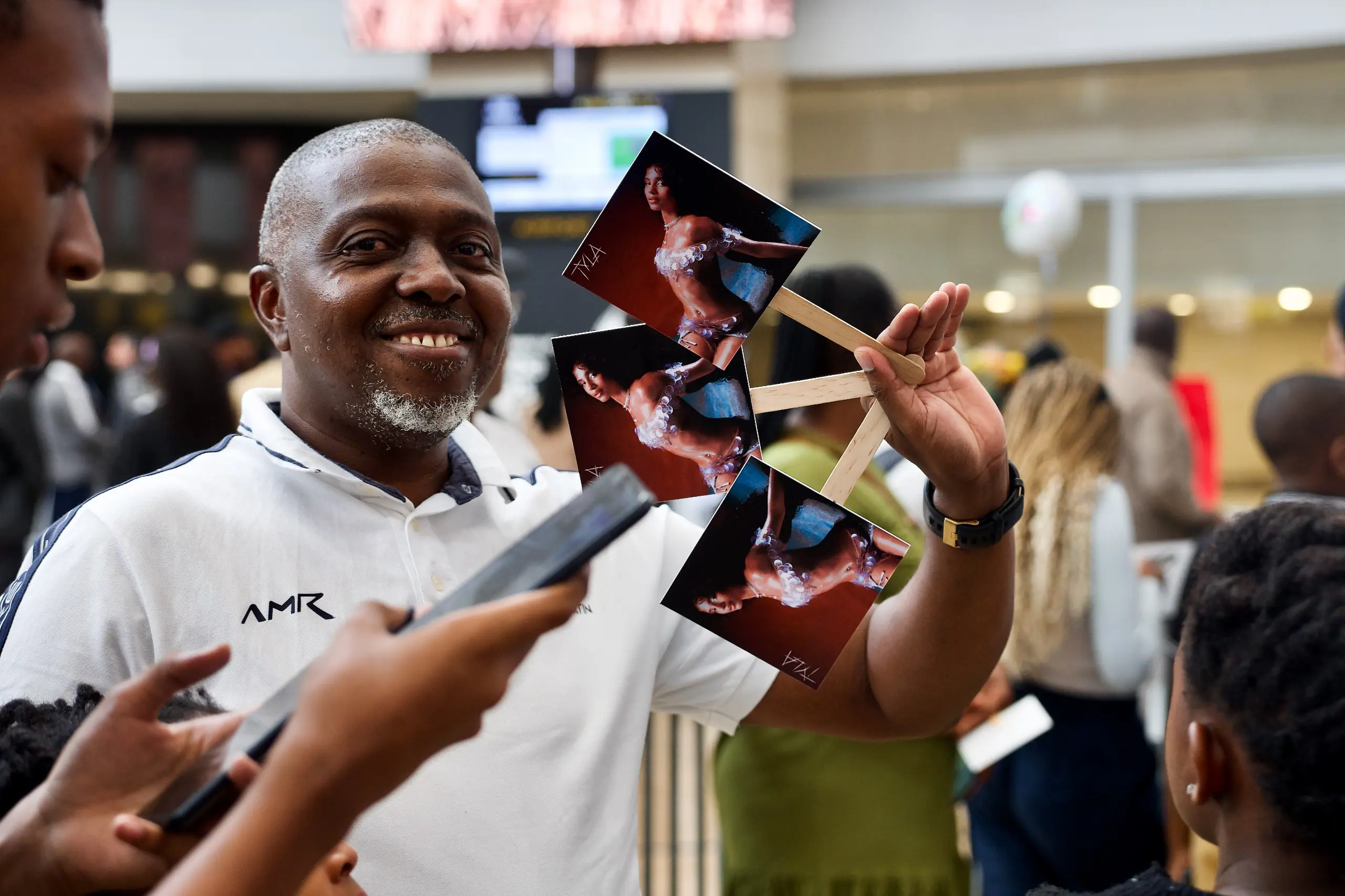 A fan brandishes images of Tyla's album when the Grammy Award-winning songstress Tyla receives a hearty welcome at the OR Tambo International Airport on 30 March 2024, since bagging the prestigious award in the United States in February. Picture: Katlego Jiyane/Eyewitness News A fan brandishes images of Tyla's album when the Grammy Award-winning songstress Tyla receives a hearty welcome at the OR Tambo International Airport on 30 March 2024, since bagging the prestigious award in the United States in February. Picture: Katlego Jiyane/Eyewitness News