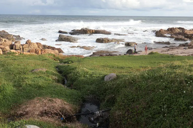 A father and daughter explore the coast at Margate, oblivious to untreated sewage running out at the beach near them. Picture: Steve Kretzmann/GroundUp A father and daughter explore the coast at Margate, oblivious to untreated sewage running out at the beach near them. Picture: Steve Kretzmann/GroundUp