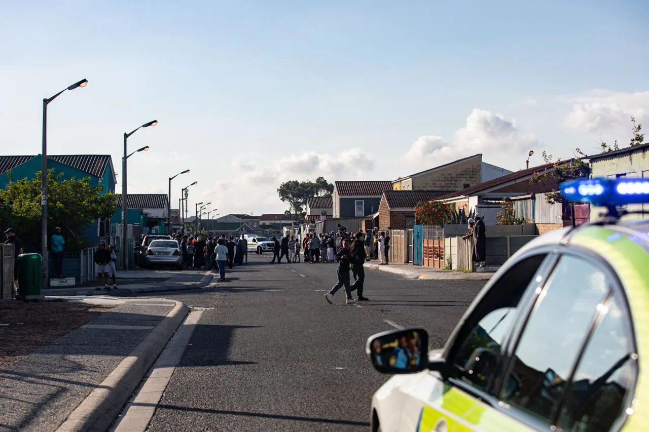Residents looked on as Western Cape Premier Alan Winde and law enforcement teams conducted a safety walk from the Mitchells Plain Police Station to Beacon Valley on 13 October 2025. Picture: Kayleen Morgan/EWN Residents looked on as Western Cape Premier Alan Winde and law enforcement teams conducted a safety walk from the Mitchells Plain Police Station to Beacon Valley on 13 October 2025. Picture: Kayleen Morgan/EWN