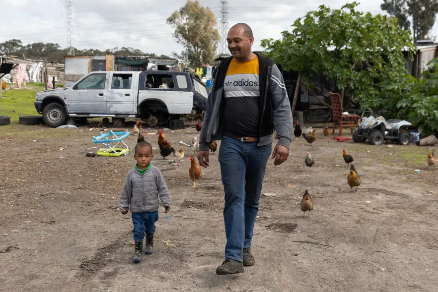 Heinrich Daniels, one of the small-scale farmers, walks with his child on his property. Picture: Ashraf Hendricks/GroundUp Heinrich Daniels, one of the small-scale farmers, walks with his child on his property. Picture: Ashraf Hendricks/GroundUp